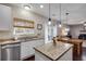 Bright kitchen with granite counters, stainless steel appliances, an island, and an open view to the dining and living areas at 5437 Blossom Brook Dr, Sugar Hill, GA 30518