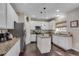 Bright kitchen with white cabinets, an island with granite countertops, and modern stainless steel appliances at 5437 Blossom Brook Dr, Sugar Hill, GA 30518