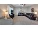 Spacious living room boasts plush seating, neutral tones, a ceiling fan, and tasteful decorative accents at 5437 Blossom Brook Dr, Sugar Hill, GA 30518