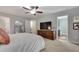 Relaxing main bedroom with a large bed, wood dresser and ceiling fan at 5437 Blossom Brook Dr, Sugar Hill, GA 30518