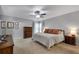 Spacious main bedroom with neutral colors, a ceiling fan, and a large bed with dark brown pillows at 5437 Blossom Brook Dr, Sugar Hill, GA 30518