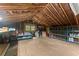 Spacious unfinished attic with open rafters, some storage shelves, and natural light from a single window at 1190 Hess Dr, Avondale Estates, GA 30002