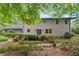 Landscaped backyard with lush greenery, patio, and white brick home featuring sliding glass doors and traditional windows at 1190 Hess Dr, Avondale Estates, GA 30002