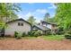 A backyard featuring a lush lawn, mature trees, and a brick home in the background, creating a serene outdoor space at 1190 Hess Dr, Avondale Estates, GA 30002