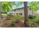 Serene backyard view showcasing mature trees, lush landscaping, and a charming white brick home at 1190 Hess Dr, Avondale Estates, GA 30002