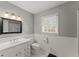 Bathroom with single vanity, toilet, framed mirror, and a window at 1190 Hess Dr, Avondale Estates, GA 30002