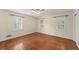 A bedroom with hardwood floors, three shuttered windows, and a ceiling fan with light at 1190 Hess Dr, Avondale Estates, GA 30002