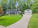Charming two-story home with a well-manicured lawn and a large driveway leading to an oversized garage at 1190 Hess Dr, Avondale Estates, GA 30002