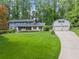 Home with a long driveway, three-car garage, and beautiful landscaping at 1190 Hess Dr, Avondale Estates, GA 30002