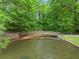 Tranquil park scene with a wooden bridge over water, surrounded by lush green trees, offering a peaceful escape at 1190 Hess Dr, Avondale Estates, GA 30002