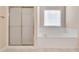 Bright bathroom featuring a tub with tile surround and a glass door shower stall at 2417 Saint Feagin Pl, Powder Springs, GA 30127