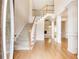 Bright foyer features hardwood floors, staircase, and elegant white columns at 2417 Saint Feagin Pl, Powder Springs, GA 30127