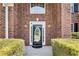 Elegant front door with glass detailing, complemented by stylish sconces and manicured bushes at 2417 Saint Feagin Pl, Powder Springs, GA 30127