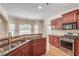 Kitchen features hardwood floors, stainless steel appliances, granite countertops, and wood cabinets at 2417 Saint Feagin Pl, Powder Springs, GA 30127