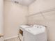 A small laundry room with a washer and dryer and a shelf at 2417 Saint Feagin Pl, Powder Springs, GA 30127