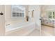 Bright bathroom featuring a large tub, tile floors, and access to the main bedroom at 525 Roland Manor Dr, Dacula, GA 30019