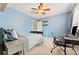 Bedroom with light blue walls, carpeted floors, ceiling fan, and a writing desk at 525 Roland Manor Dr, Dacula, GA 30019