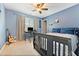 Bedroom with light blue walls, carpeted floors, ceiling fan, and a writing desk at 525 Roland Manor Dr, Dacula, GA 30019