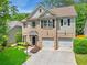 Charming two-story home featuring a brick facade, two-car garage, and beautifully landscaped front yard at 525 Roland Manor Dr, Dacula, GA 30019