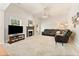 Bright living room with fireplace, plush carpet, fan, and comfortable dark leather furniture at 525 Roland Manor Dr, Dacula, GA 30019