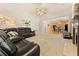 Open-concept living room with fireplace, fan, and comfortable dark leather furniture at 525 Roland Manor Dr, Dacula, GA 30019