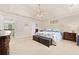 Spacious main bedroom featuring tray ceilings, a ceiling fan, carpeted floors, and an ensuite bathroom at 525 Roland Manor Dr, Dacula, GA 30019