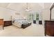 Spacious main bedroom featuring a tray ceiling, neutral decor, and a large window for natural light at 525 Roland Manor Dr, Dacula, GA 30019