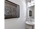 Stylish powder room with a pedestal sink, modern lighting, and decorative artwork at 1569 Aiden Way # 35, Conyers, GA 30013