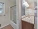 A view of the tub and shower in a bathroom with an adjoining view of the vanity and mirror at 1584 Allgood Ne Rd, Marietta, GA 30062