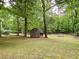 Spacious backyard with mature trees, a shed, and plenty of room for outdoor activities at 5364 Muirwood Pl, Powder Springs, GA 30127