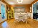 Charming dining room featuring a round table with seating, hardwood floors, and a yellow cabinet, perfect for gatherings at 5364 Muirwood Pl, Powder Springs, GA 30127