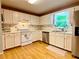 Bright kitchen features white cabinets, stainless steel appliances, and hardwood floors at 5364 Muirwood Pl, Powder Springs, GA 30127