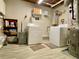 Functional laundry room with modern washer and dryer and storage shelving at 5364 Muirwood Pl, Powder Springs, GA 30127