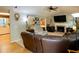 Inviting living room with a brick fireplace, ceiling fan, and large tv providing an inviting atmosphere for relaxation at 5364 Muirwood Pl, Powder Springs, GA 30127