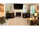 Cozy living room featuring a brick fireplace with mounted TV and built-in shelves providing both style and functionality at 5364 Muirwood Pl, Powder Springs, GA 30127