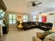 Well-lit living room featuring a brick fireplace, vaulted ceilings, plush seating, and a view of the front entrance at 5364 Muirwood Pl, Powder Springs, GA 30127