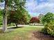 Landscaped front yard with colorful trees and view of the quiet residential street at 5364 Muirwood Pl, Powder Springs, GA 30127