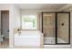 Bathroom with a tub, glass shower and window at 626 Discovery Ct, Acworth, GA 30102