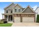 Charming two-story home with stone accents, manicured lawn, and a two-car garage at 626 Discovery Ct, Acworth, GA 30102