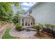 A charming outdoor patio area with landscaped garden and stone pathway to a bright sunroom entrance at 7750 Landowne Dr, Atlanta, GA 30350