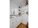 Home bar area with hardwood floors, white cabinets, marble countertop, and mirrored backdrop at 7750 Landowne Dr, Atlanta, GA 30350