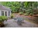 Serene patio area with an outdoor table and chairs, and professional landscaping at 7750 Landowne Dr, Atlanta, GA 30350