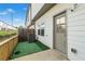 View of a fenced-in backyard with synthetic turf, patio, and an exterior door at 1388 Ben Park Way, Grayson, GA 30017