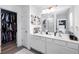 Bathroom with a double sink vanity, white cabinetry, modern fixtures, and a walk-in closet at 1388 Ben Park Way, Grayson, GA 30017