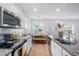 Modern kitchen with stainless steel appliances, granite countertops, and a view of the dining area at 1388 Ben Park Way, Grayson, GA 30017