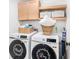 A well-organized laundry room with matching washers and dryers and storage cabinets and shelves at 1388 Ben Park Way, Grayson, GA 30017