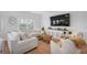 Well-lit living room featuring a cozy sectional sofa, decorative accents, and wood flooring at 1388 Ben Park Way, Grayson, GA 30017