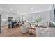 Open living space with hardwood floors, white cabinets, a kitchen island, and comfortable seating at 1388 Ben Park Way, Grayson, GA 30017