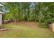 Expansive, partially-wooded backyard featuring mature trees and lush greenery surrounded by a wooden fence at 4781 Lincoln Ne Dr, Kennesaw, GA 30144