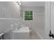 Clean, all white bathroom featuring a bathtub and updated fixtures at 4781 Lincoln Ne Dr, Kennesaw, GA 30144